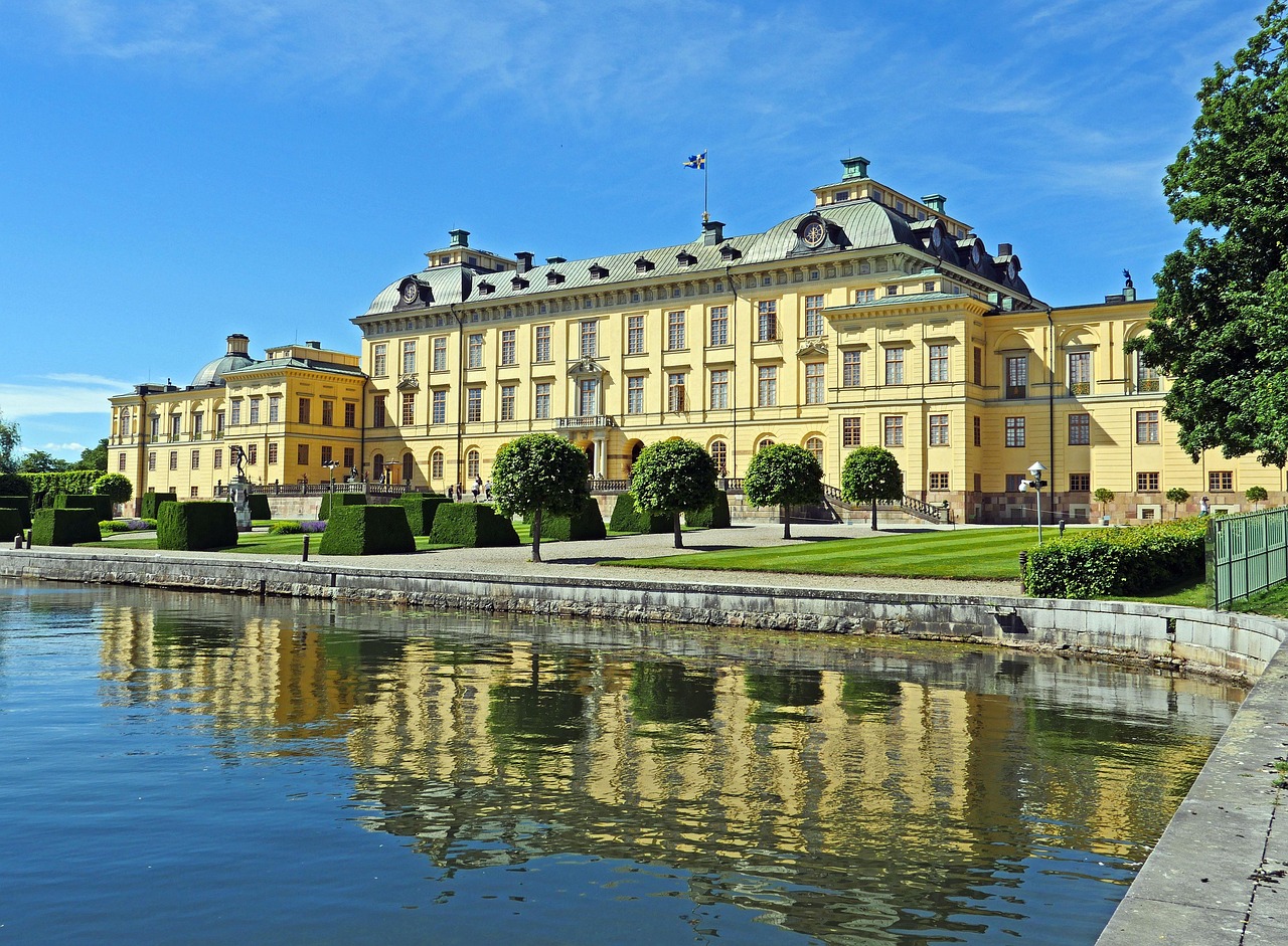 Drottningholm-palace in Sweden, large yellow exterior with water feature in front and landscaping in front of building.
image is on the Publications page